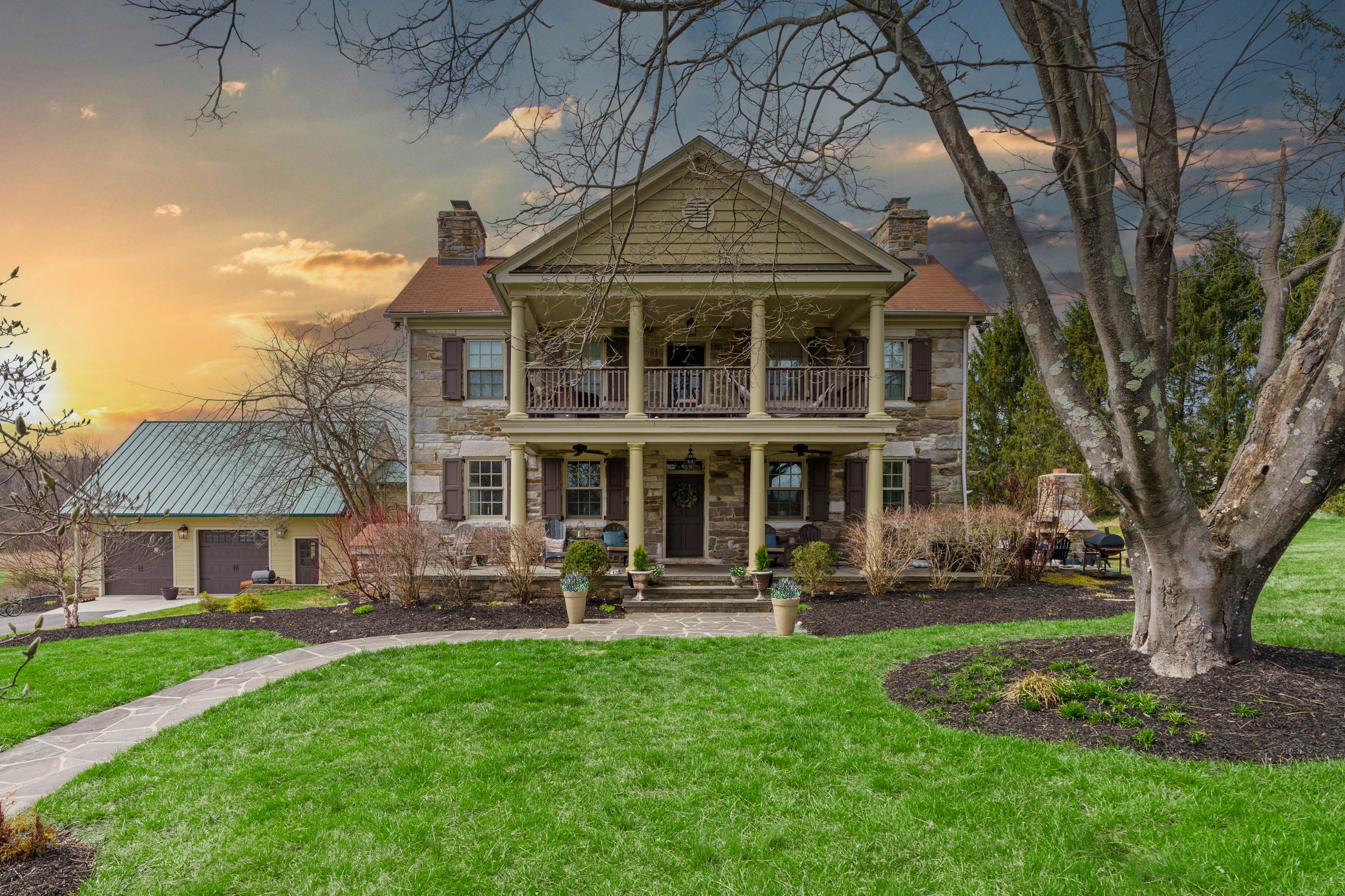 15314 PRICEVILLE ROAD, SPARKS GLENCOE, MD 21152 – Historic stone manor house at twilight with two-story front porch and expansive manicured lawn