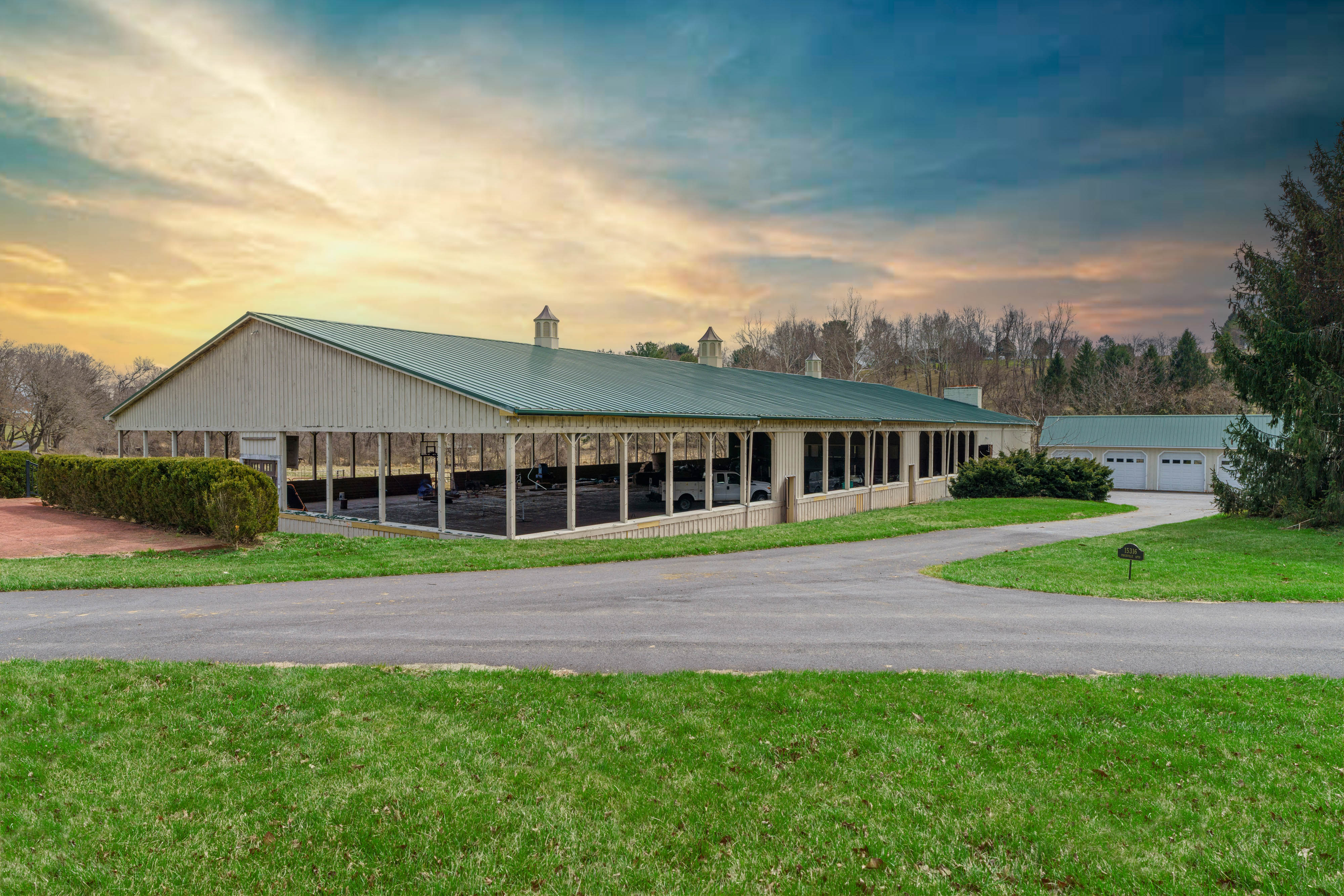 15314 PRICEVILLE ROAD, SPARKS GLENCOE, MD 21152 – Long green-roofed barn beside a paved drive and open lawn at sunset