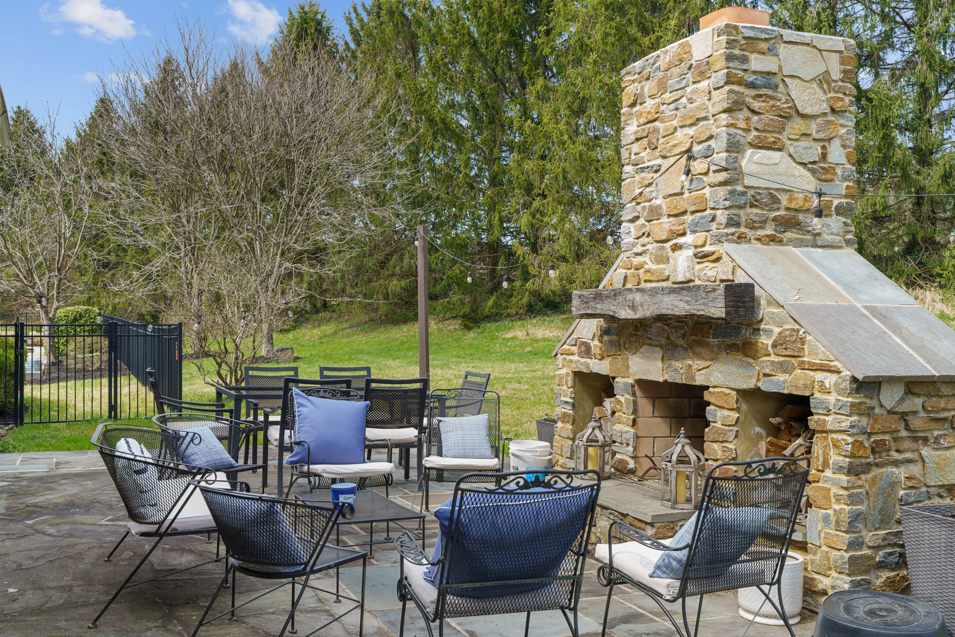 15314 PRICEVILLE ROAD, SPARKS GLENCOE, MD 21152 – Stone patio with outdoor fireplace and cushioned lounge seating surrounded by mature trees