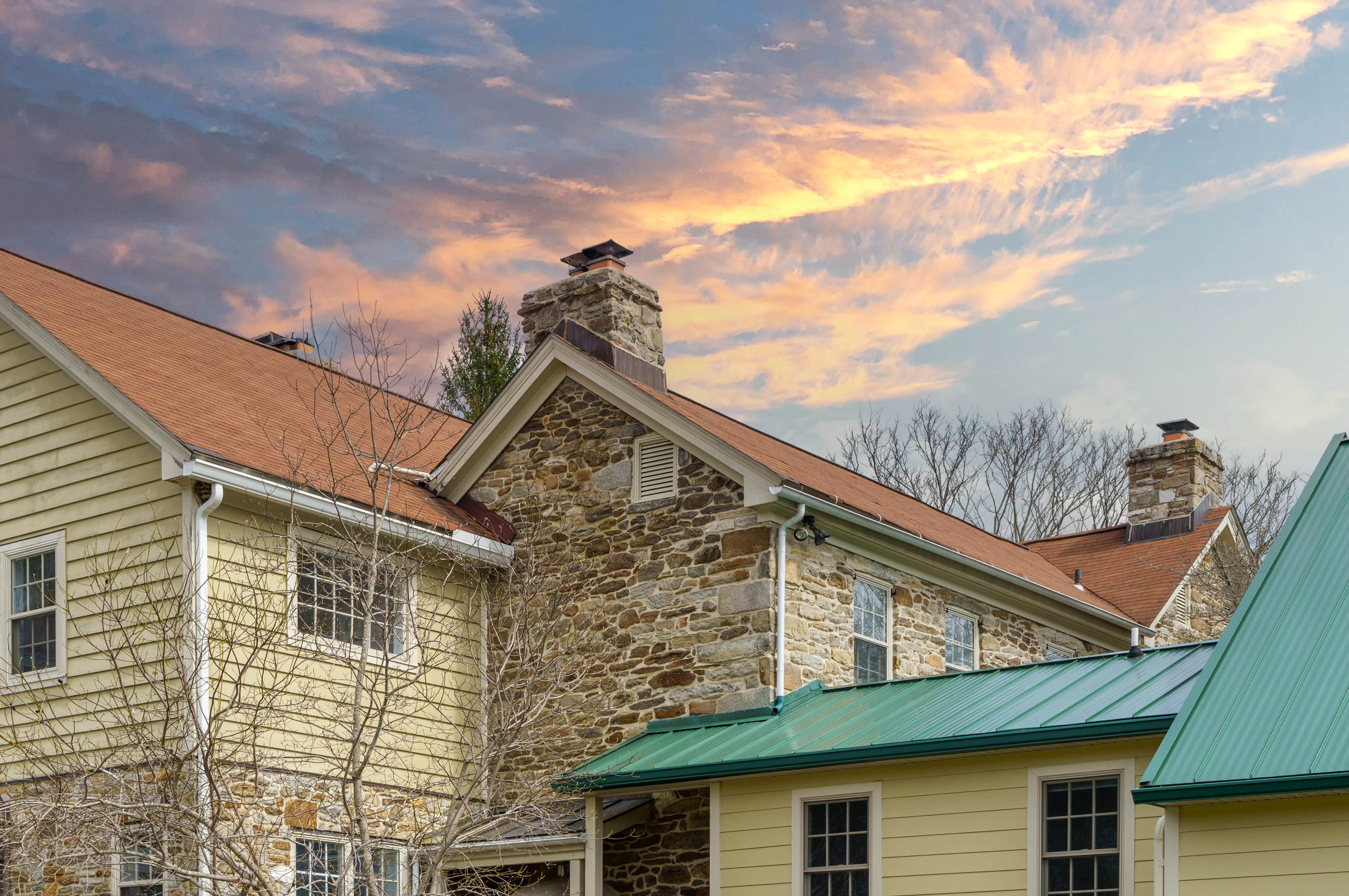 15314 PRICEVILLE ROAD, SPARKS GLENCOE, MD 21152 – Fieldstone manor facade with chimneys and green metal roof accents at sunset