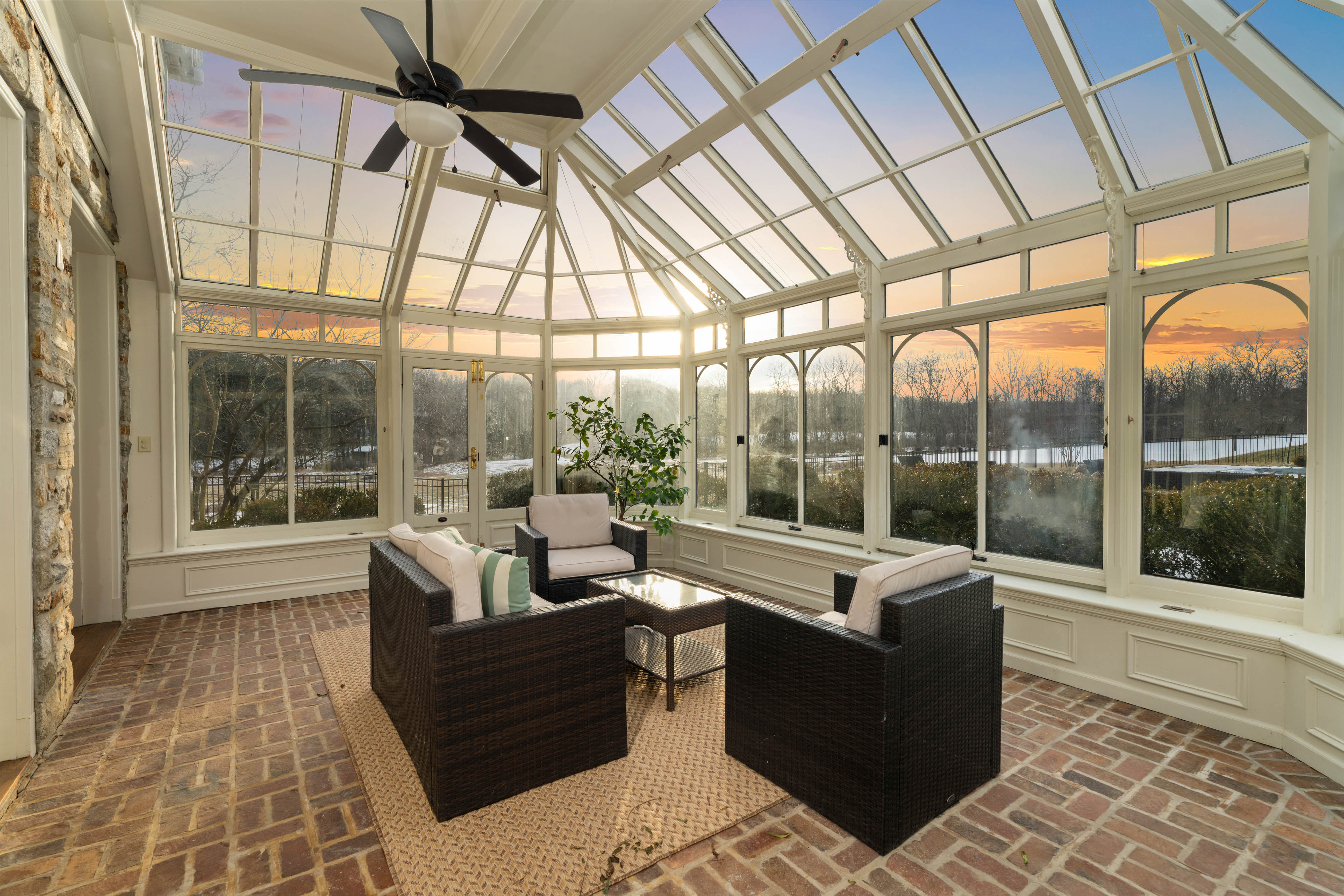 15314 PRICEVILLE ROAD, SPARKS GLENCOE, MD 21152 – Luminous glass sunroom with ceiling fan, leather seating, and sunset views over the Baltimore County countryside